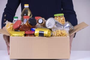 Woman Volunteer Hands Holding Food Donation Box With Food Grocer
